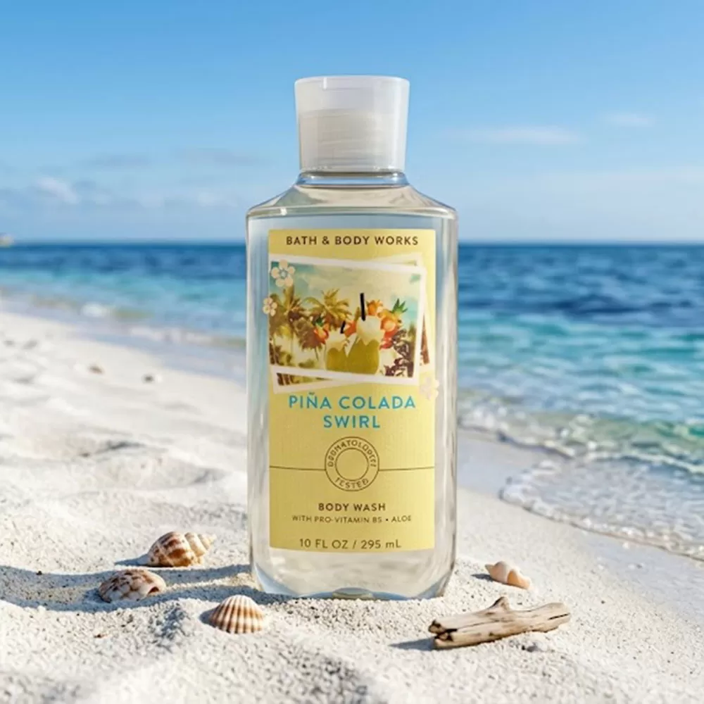 Sữa tắm unisex Body Wash | Bath & Body Works Piña Colada Swirl - chai sữa tắm unisex Bath & Body Works Piña Colada Swirl trên bàn gỗ trắng, ánh sáng từ chính.