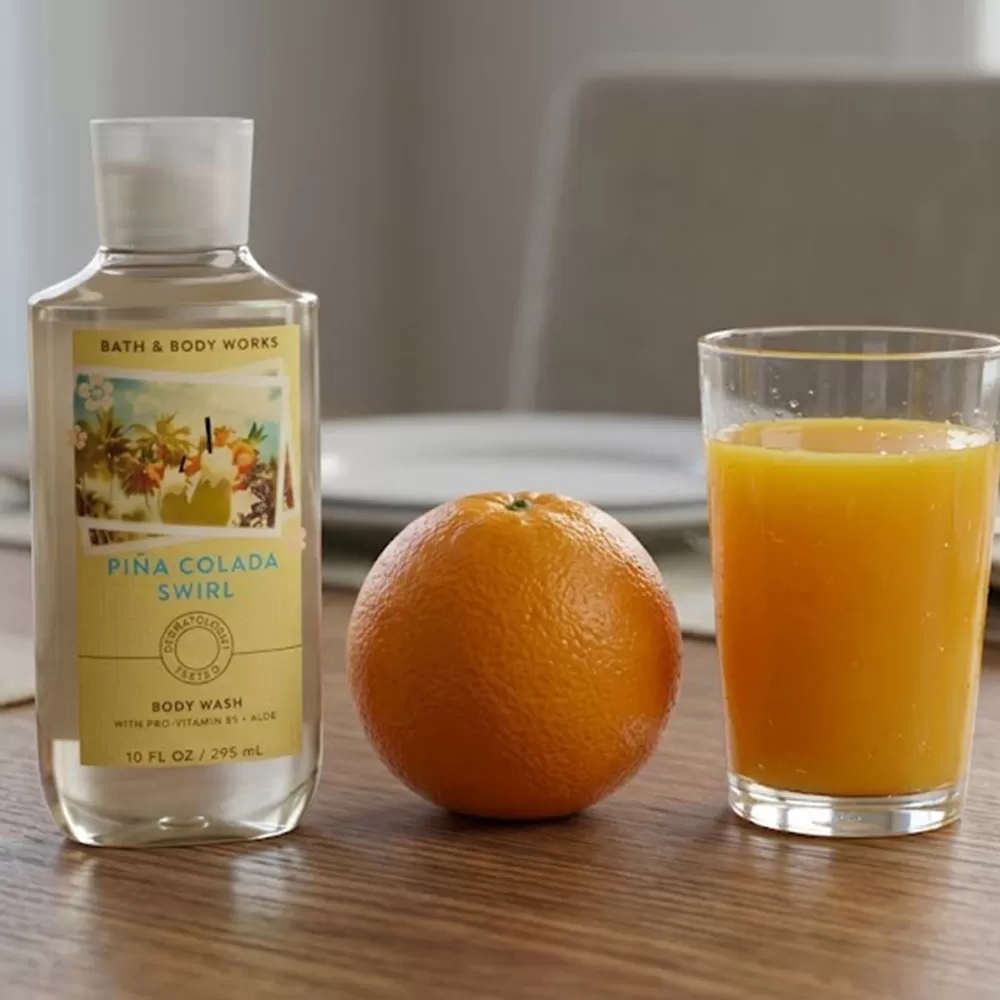 Sữa tắm unisex Body Wash | Bath & Body Works Piña Colada Swirl - chai sữa tắm Bath & Body Works Piña Colada Swirl trên kệ tủ trong phòng tắm hiện đại.